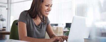 一个女人在用笔记本电脑工作，她的手放在键盘上